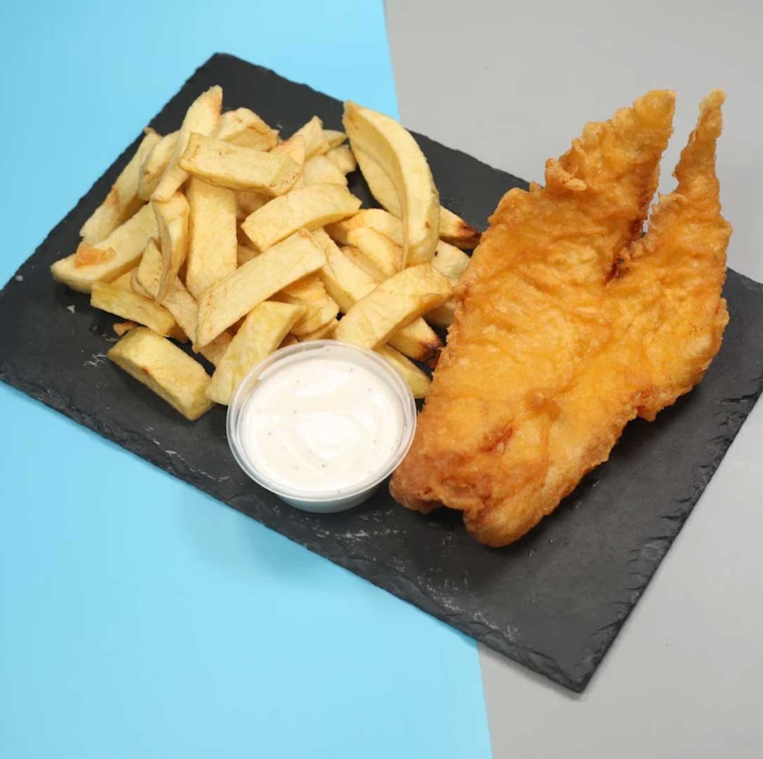 Golden fried fish fillet and thick-cut chips on a black serving platter in Rosyth. 